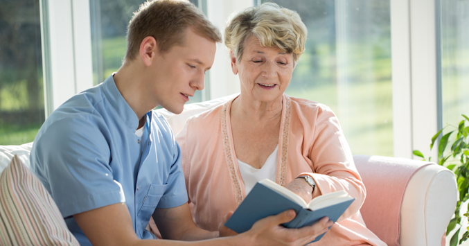 person reading to an elderly person