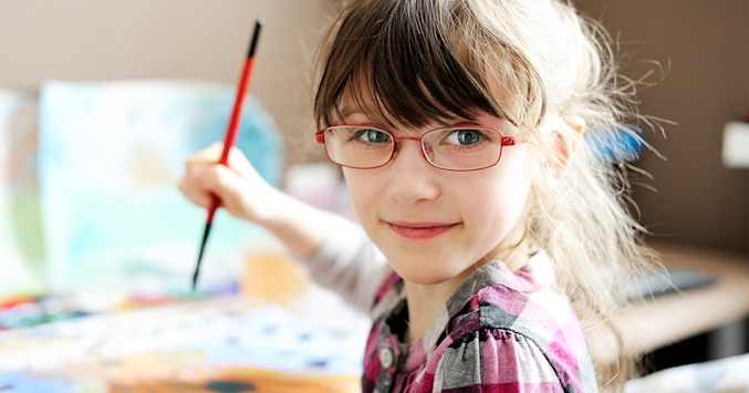 Preschool girl wearing eyeglasses while painting