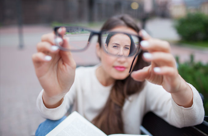 Woman looking at a pair of eyeglasses