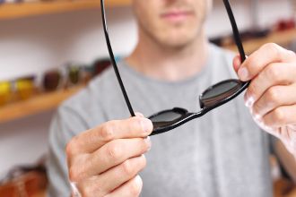 Homem experimentando óculos de sol de prescrição