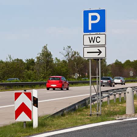 Das Bild zeigt das Hinweisschild auf einen Autobahnparkplatz mit WC.