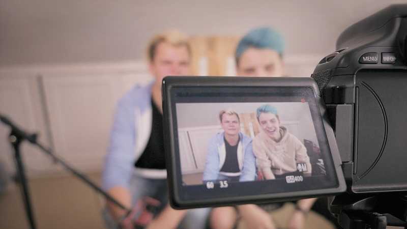 Die YouTuber Fabian und Tobias des Kanals die Grischis sitzen vor einer Kamera und reden.