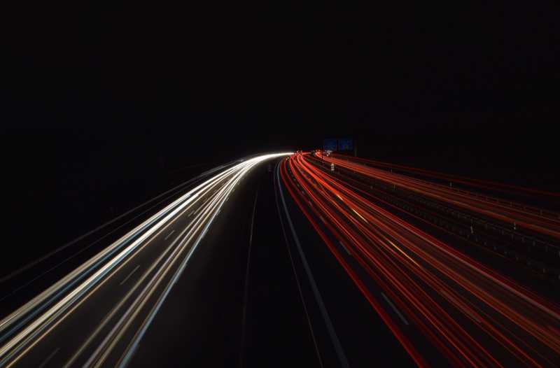 verschwimmende Autolichter auf der Autobahn in der Nacht.