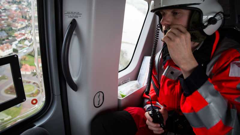 Das Bild zeigt den Notarzt Stefan Gerke im Cockpit des Hubschraubers. Über ein Headset verständigt er ich mit Kollegen über den Einsatz.