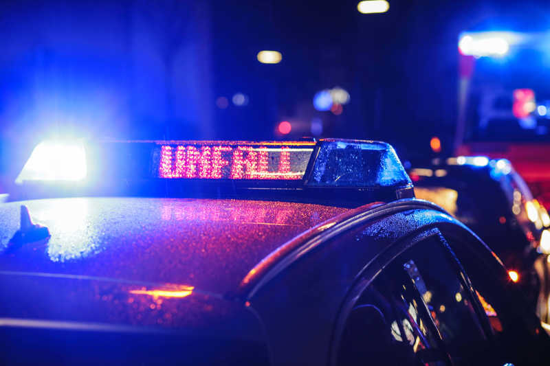Das Dach eines Polizeiautos. Das Blaulicht ist eingeschaltet und eine LED zeigt „Unfall“. 