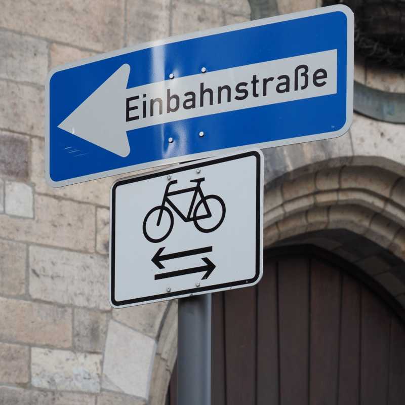 Verkehrszeichen Einbahnstraße mit dem Zusatzzeichen, das Fahrradfahren in beide Richtungen erlaubt.