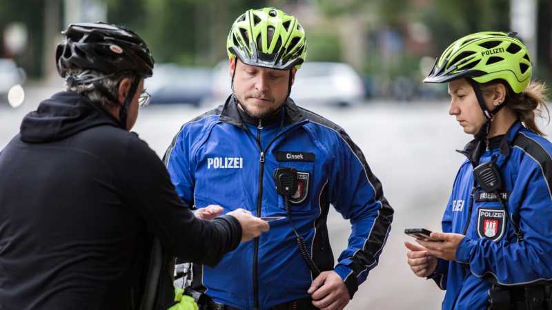 Die Fahrradpolizisten erheben per Smartphone die Daten des Radfahrers.