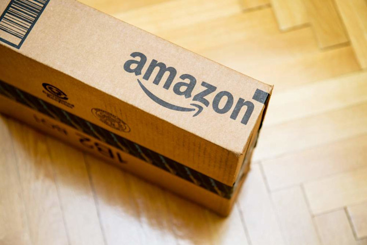 An Amazon box sits unopened on the floor of a home.