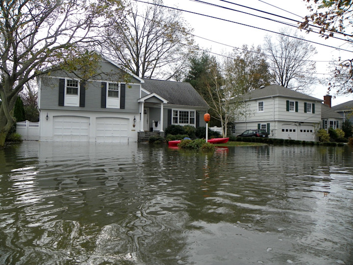 Flood water covers the street of a neighborhood.