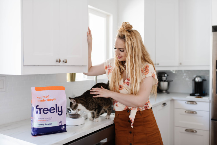 Cat eating Freely pet food on counter