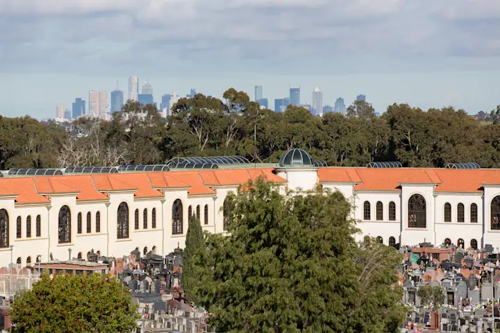 Melbourne's skyline rises above Preston Mausoleum at Preston Cemetery in Bundoora