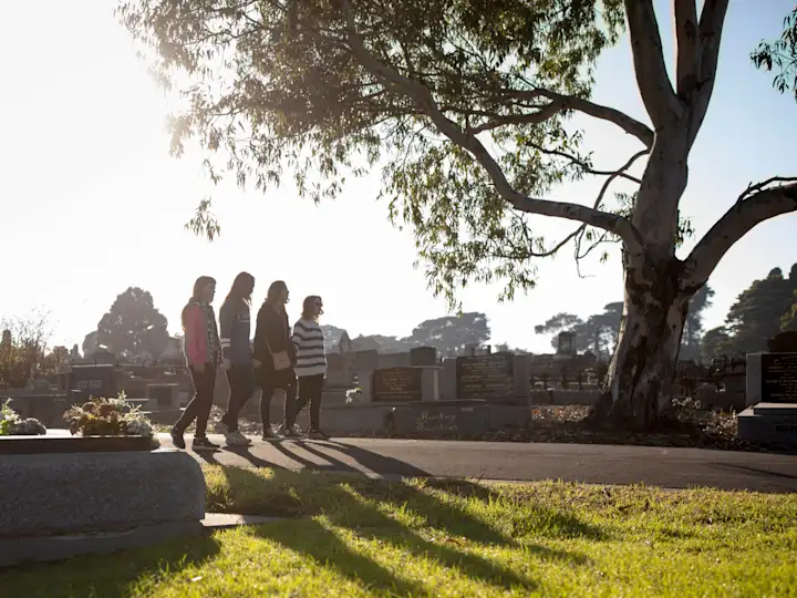 Four young women walking through Coburg Pine Ridge Cemetery in the early morning light
