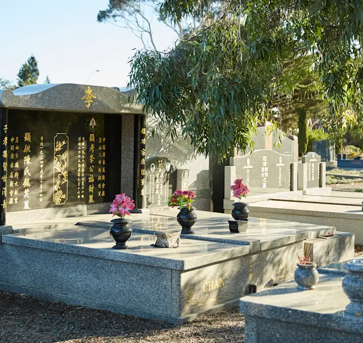 Monumental grave with flower vases and eucalyptus tree foliage, Fawkner Memorial Park