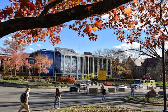People walking along University Avenue in front of the Mountainlair Student Union on a bright fall day
