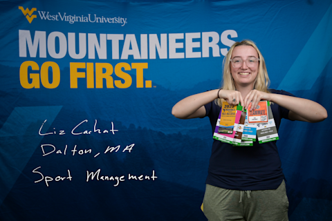 Liz Cachat, a Sport Management major from Dalton, MA, holds a collection of press passes.