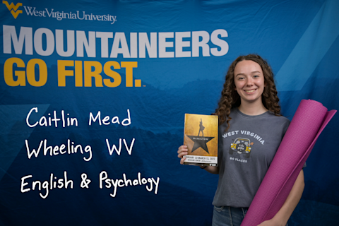 Caitlin Mead, an English and Psychology major from Wheeling, WV, holds a pink yoga mat and a program from Hamilton.