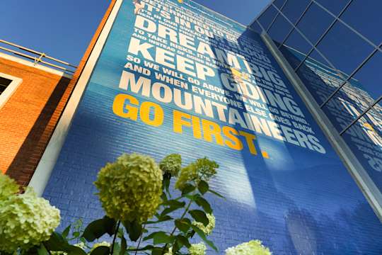Mural on front of Mountainlair student union: Dream big. Keep going. Mountaineers Go First.