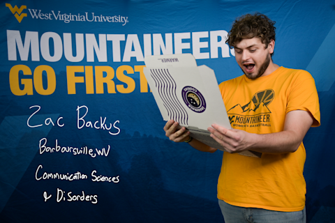 Zac Backus, a Communication Sciences and Disorders major from Barboursville, WV, gasps as he looks inside an Insomnia Cookies box.