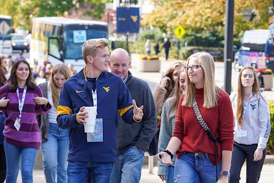 Student guide talks with a prospective student while leading a tour on the downtown area of campus