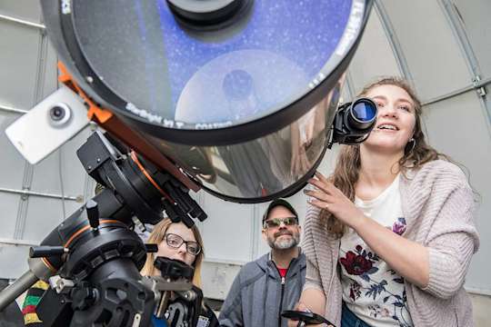 Astronomy students use telescope in observatory