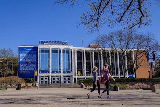 Two women walk in front of the Mountainlair