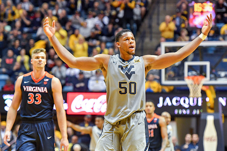 Men's Basketball player Sagaba Konate raises his arms to pump up the crowd at the home game against Virginia