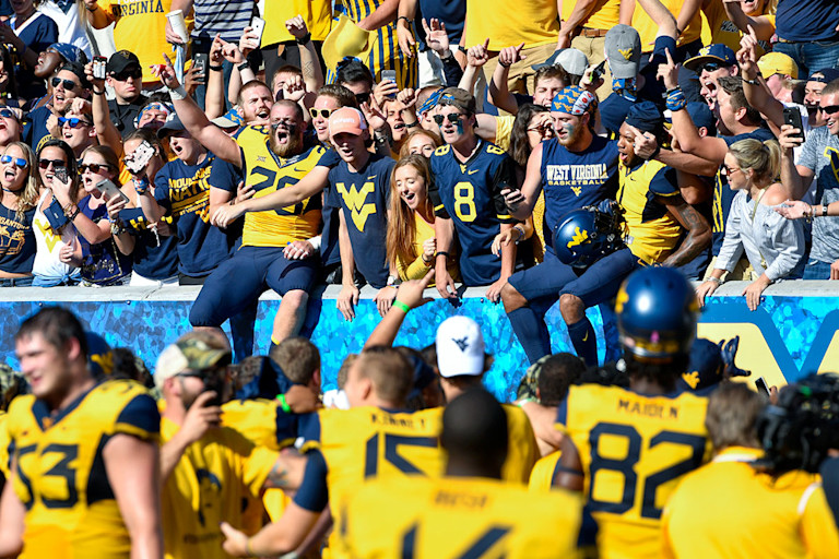 Football players join the student section to sing 'Take Me Home, Country Roads' at Milan Puskar Stadium