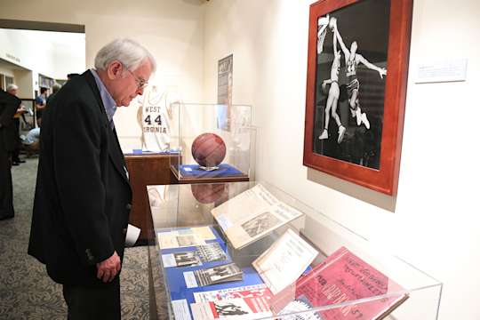 A library visitor examines an exhibit featuring memorabilia from the Library's Jerry West collection