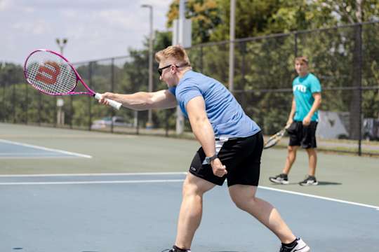 People playing tennis on the Evansdale tennis courts.