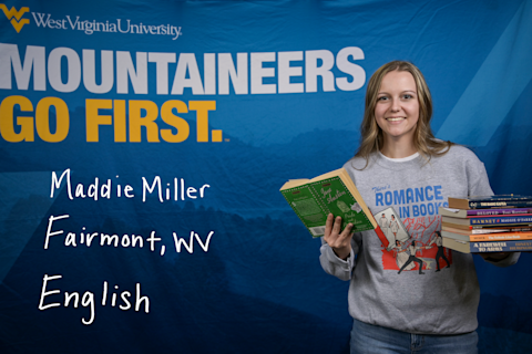 Maddie Miller, an English major from Fairmont, WV, wears a "There's Romance in Books" T-shirt and holds a stack of books in her left hand. She holds open a copy of Jane Austen's "Pride and Prejudice" in her right hand.
