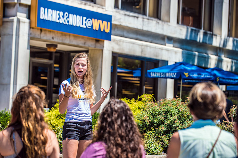 Tour guide speaks to group in front of Barnes & Noble WVU Bookstore.