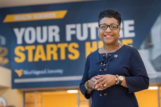 Portrait of Dr. Alexander in front of "Your Future Starts Here" mural