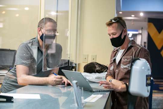 A student gets account assistance from a WVU employee