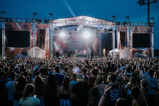 A crowd packs the Rec Fields as performers sing on stage.