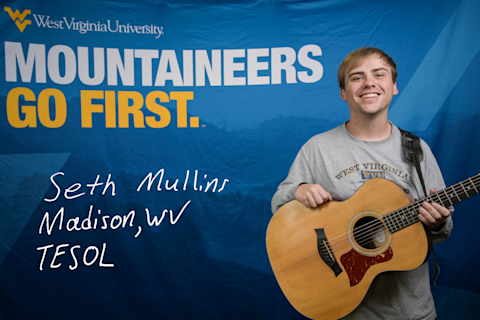 Seth Mullins, a TESOL major from Madison, WV, smiles while hold a guitar.