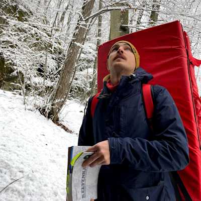 Me holding a guide book and looking up front of a snowy background