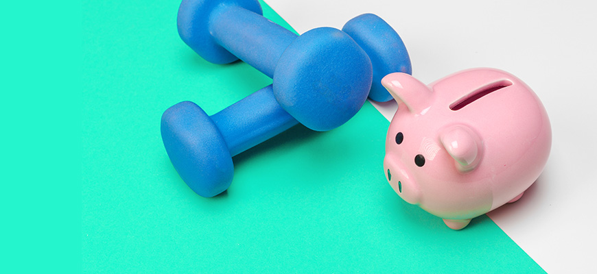 Weights and a piggy bank representing financial fitness