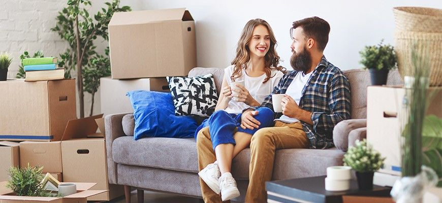 Man and woman on a couch with moving boxes