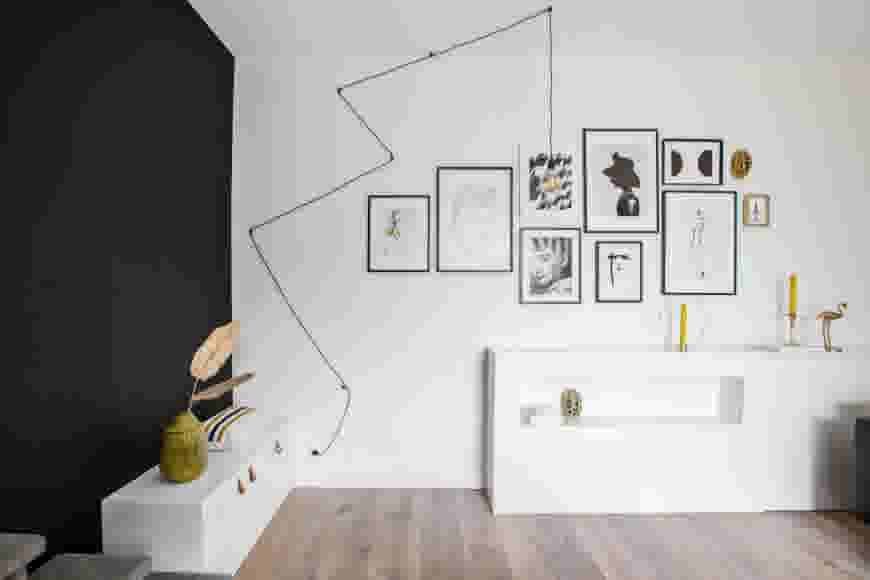 Kamer met een zwarte muur en een witte muur met fotolijsten
