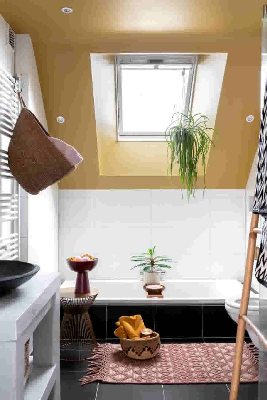 Badkamer met een donkere vloer combineren met witte tegels en een geel plafond