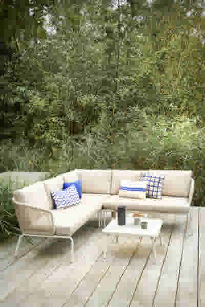 Beige loungebank moderne tuin met blauw witte sierkussens