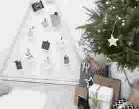 Houten kerstkaartenstandaard tegen witte muur