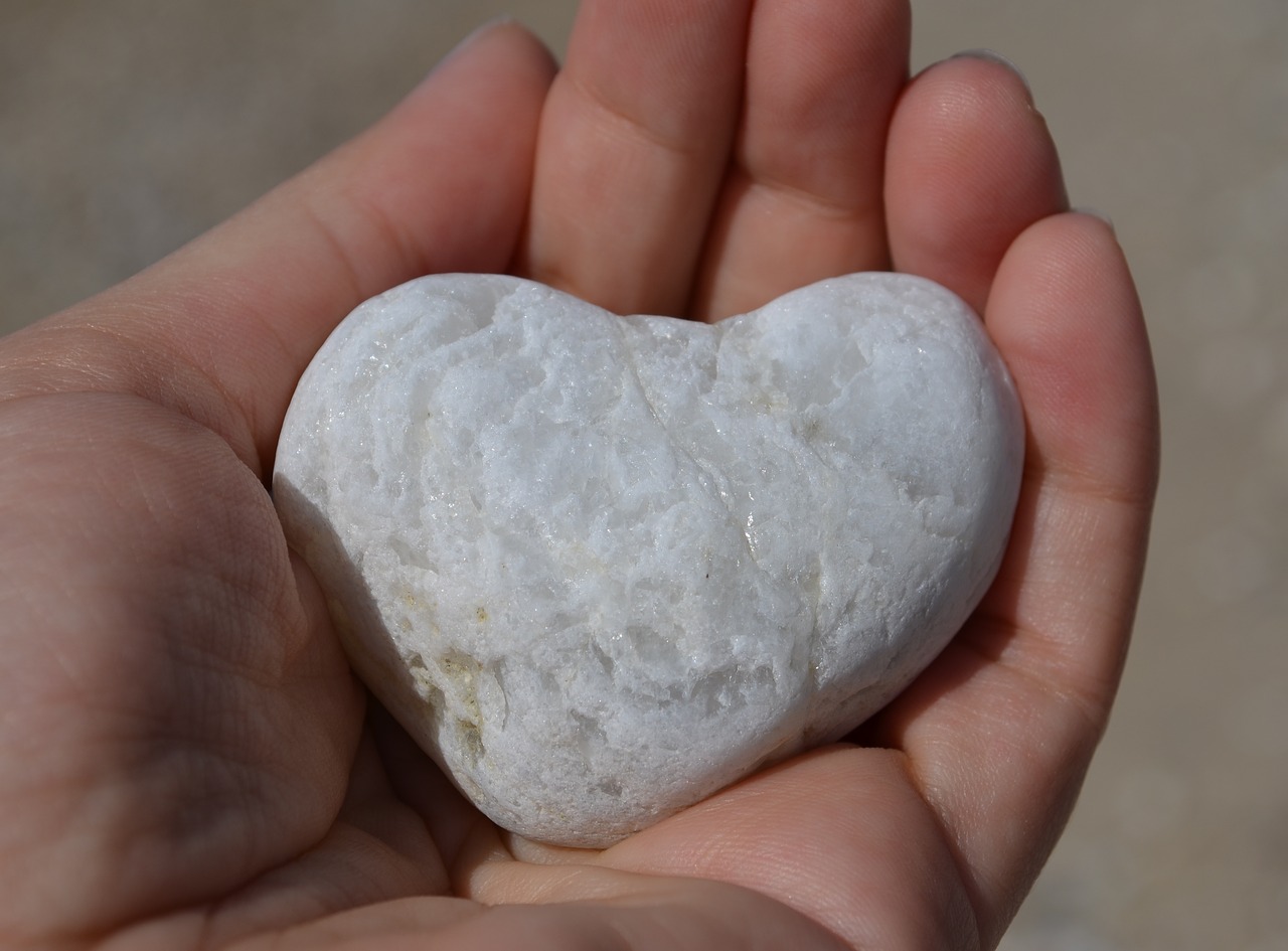 Hand holding a heart shaped stone