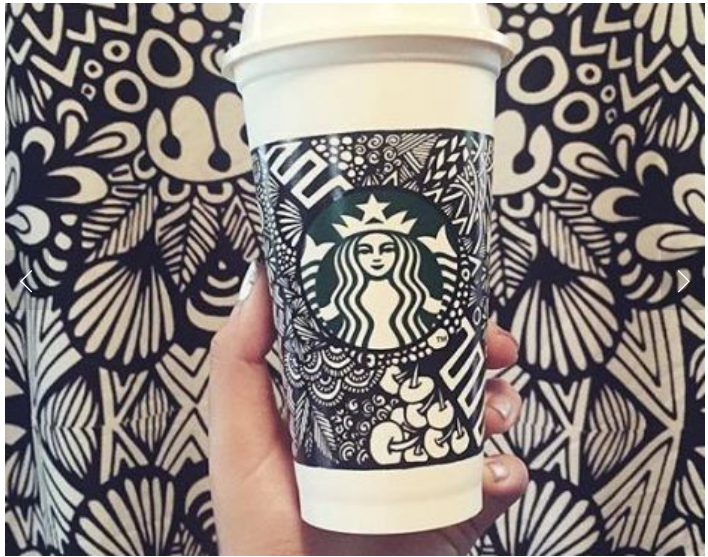A Starbucks cup that a customer has drawn creative sketches on.
