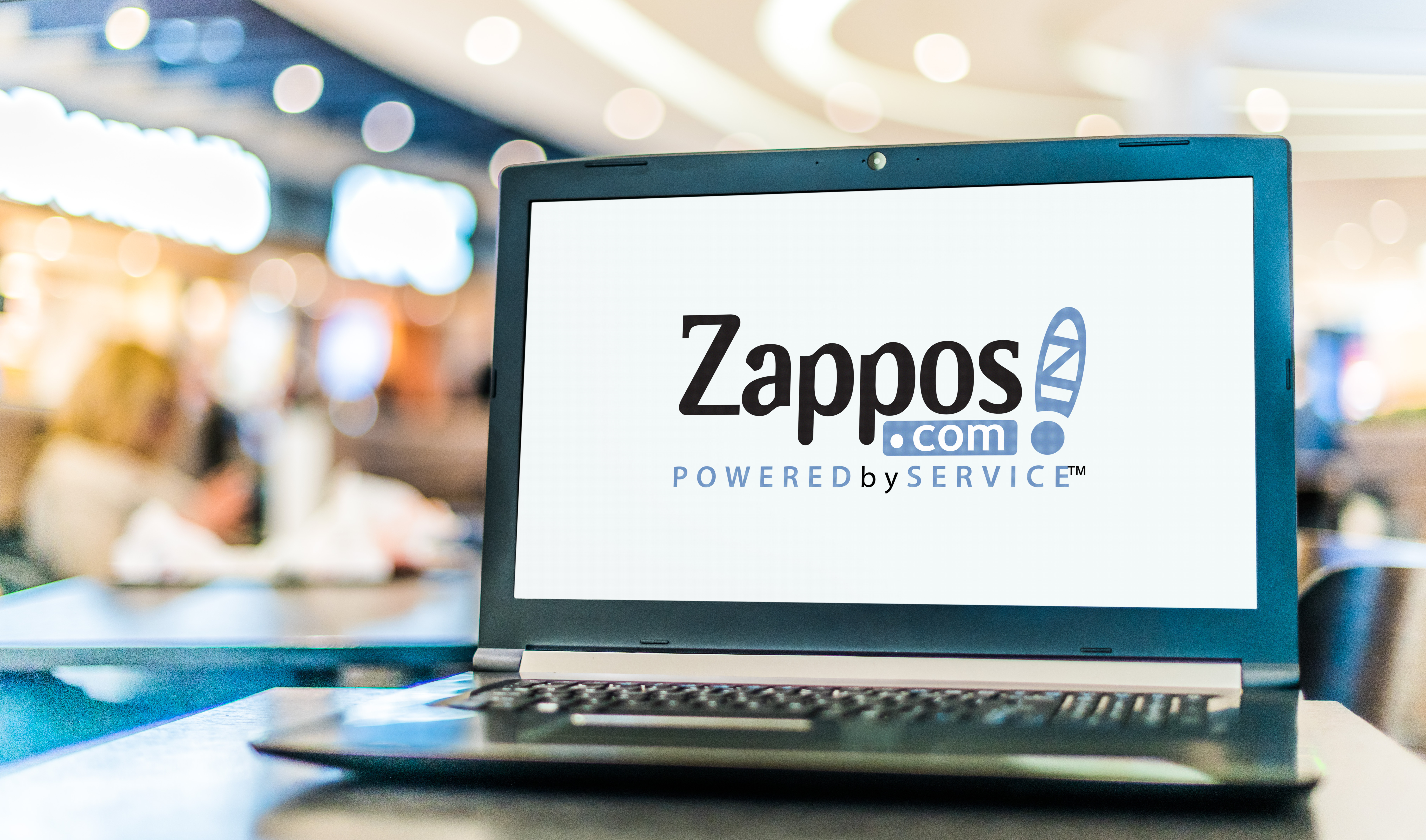 A laptop showcasing the brand name Zappos with the tagline, powered by service.