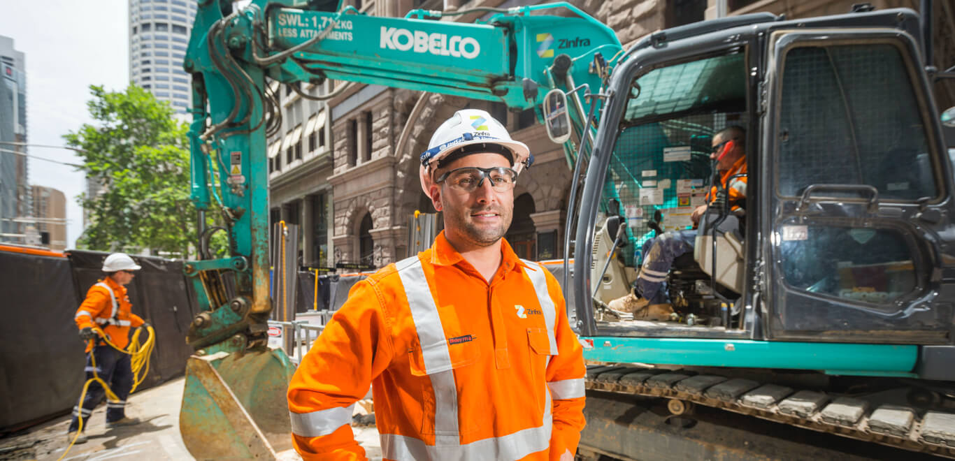 Construction worker in front of a digger