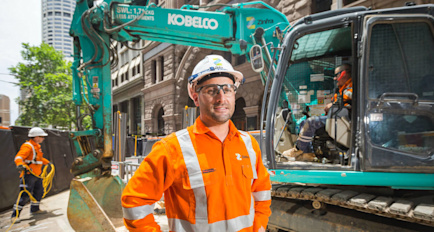Construction worker in front of a digger