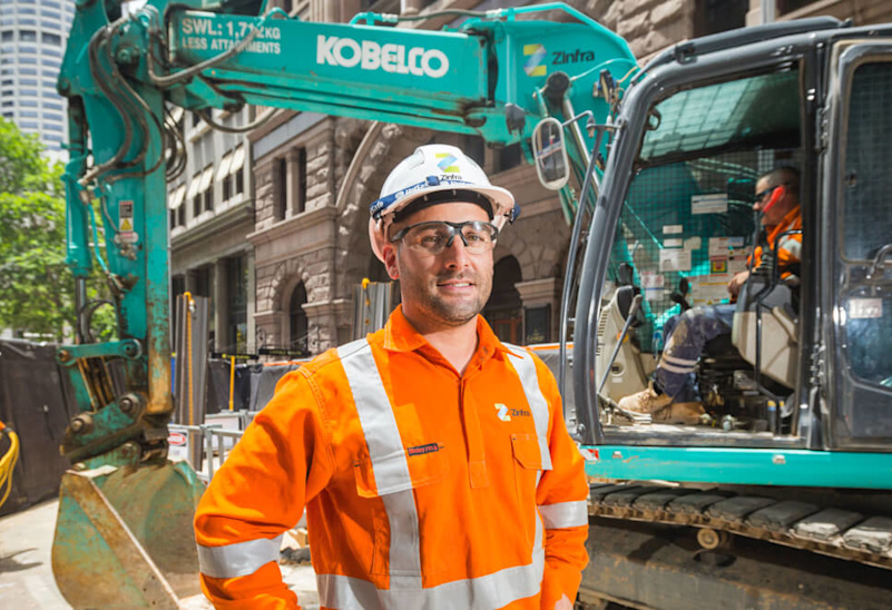 Construction worker in front of a digger