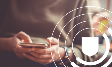 Person sitting and using a smartphone, with a shield icon overlay on the image.