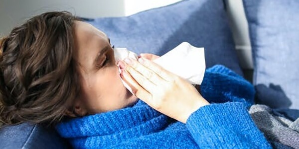 A woman is blowing her nose